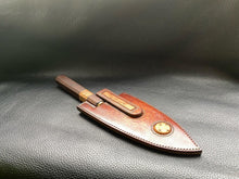 Load image into Gallery viewer, Hand dyed sunburst tan to brown Leather outer with Ostrich skin inlays and blue layers with a unique magnet securing mechanism. Fully handmade leather knife sheath which is completely hand stitched and hand finished to ensure the knife within is protected from the elements. We can design to our customer specifications to ensure you get a truly unique and bespoke item.www.leathercompositions.com