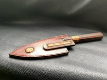 Load image into Gallery viewer, Hand dyed sunburst tan to brown Leather outer with Ostrich skin inlays and blue layers with a unique magnet securing mechanism. Fully handmade leather knife sheath which is completely hand stitched and hand finished to ensure the knife within is protected from the elements. We can design to our customer specifications to ensure you get a truly unique and bespoke item.www.leathercompositions.com