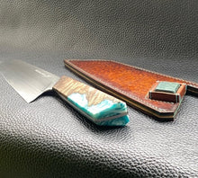 Load image into Gallery viewer, Hand dyed sunburst tan to brown Veg Tanned Leather outer with blue inserts and unique magnet securing mechanism. Fully handmade leather knife sheath which is completely hand stitched and hand finished to ensure the knife within is protected from the elements. We can design to our customer specifications to ensure you get a truly unique and bespoke item.www.leathercompositions.com
