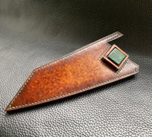 Load image into Gallery viewer, Hand dyed sunburst tan to brown Veg Tanned Leather outer with blue inserts and unique magnet securing mechanism. Fully handmade leather knife sheath which is completely hand stitched and hand finished to ensure the knife within is protected from the elements. We can design to our customer specifications to ensure you get a truly unique and bespoke item.www.leathercompositions.com
