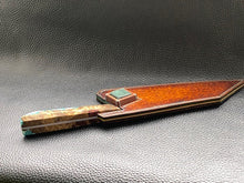 Load image into Gallery viewer, Hand dyed sunburst tan to brown Veg Tanned Leather outer with blue inserts and unique magnet securing mechanism. Fully handmade leather knife sheath which is completely hand stitched and hand finished to ensure the knife within is protected from the elements. We can design to our customer specifications to ensure you get a truly unique and bespoke item.www.leathercompositions.com
