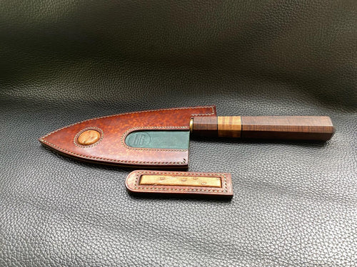 Hand dyed sunburst tan to brown Leather outer with Ostrich skin inlays and blue layers with a unique magnet securing mechanism. Fully handmade leather knife sheath which is completely hand stitched and hand finished to ensure the knife within is protected from the elements. We can design to our customer specifications to ensure you get a truly unique and bespoke item.www.leathercompositions.com